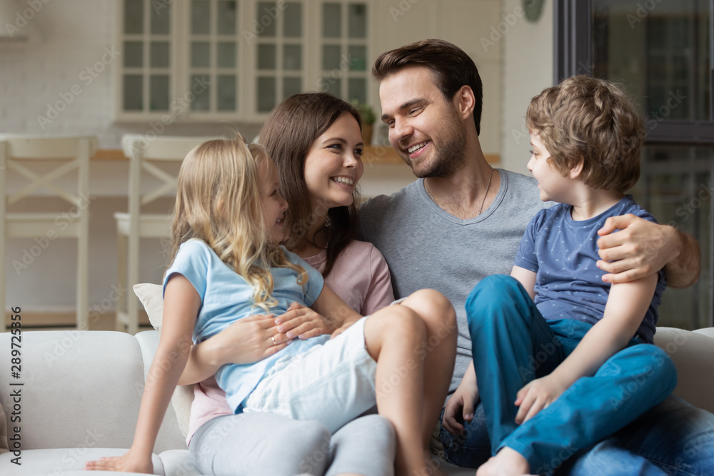 Happy young family couple keeping on lap little cute children. Happy young family couple keeping on lap little cute children.
