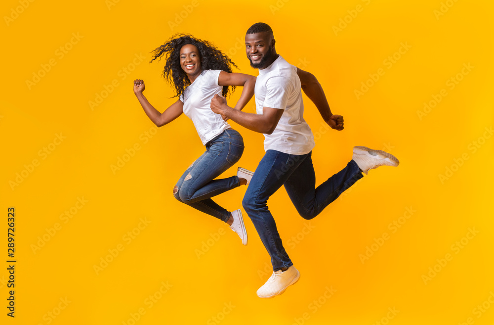 Playful african couple is running in the air - obrazy, fototapety, plakaty 