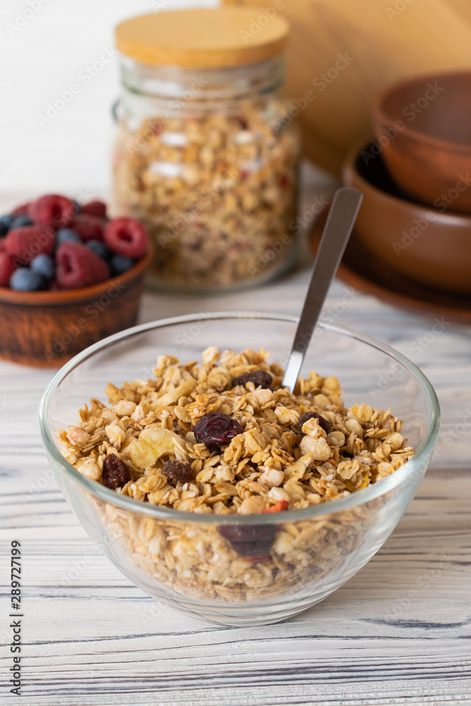 Homemade granola with raisins, nuts and berries in a glass bowl Homemade granola with raisins, nuts and berries in a glass bowl