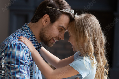 Head shot portrait overjoyed young dad playing with daughter.