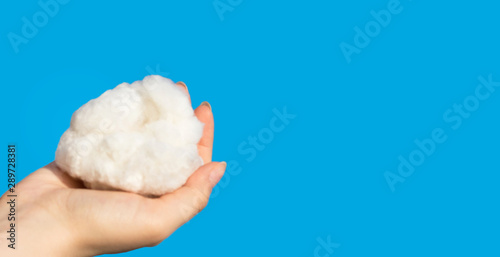 hand holding cotton on blue background