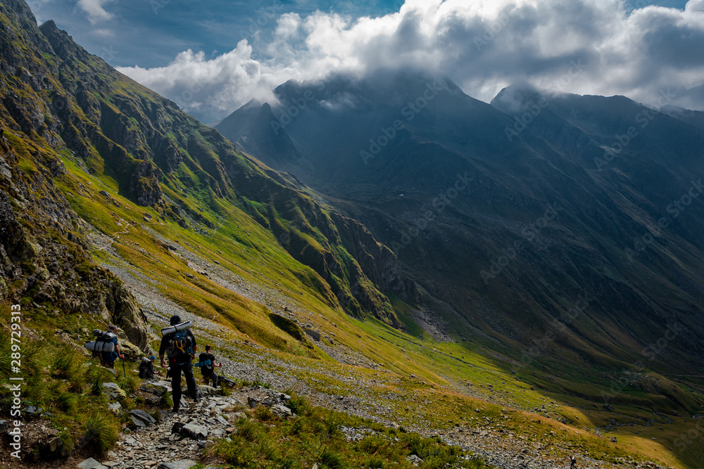 Tourists walking on the path from the top of the mountain. Fagaras Mountains, Romania