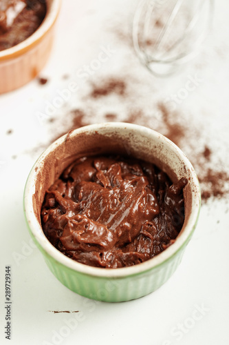 Cooking chocolate fondant - dessert composed of small chocolate cake. Dough in baking dish for oven cook