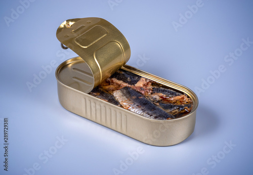 Open canned food with smoked herring on a gray background