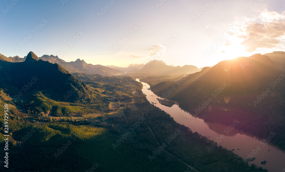 Aerial panoramic Nam Ou River Nong Khiaw Muang Ngoi Laos, sunset dramatic sky, scenic mountain landscape, famous travel destination in South East Asia