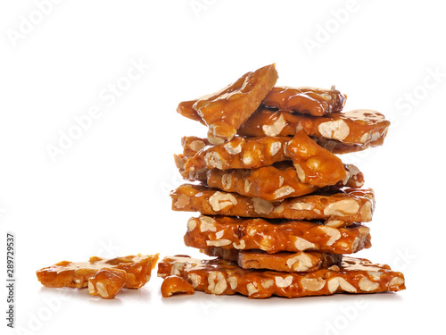Stack of traditional peanut brittle candy pieces, isolated on a white background