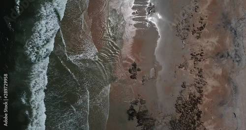 Beach waves on rocks from above