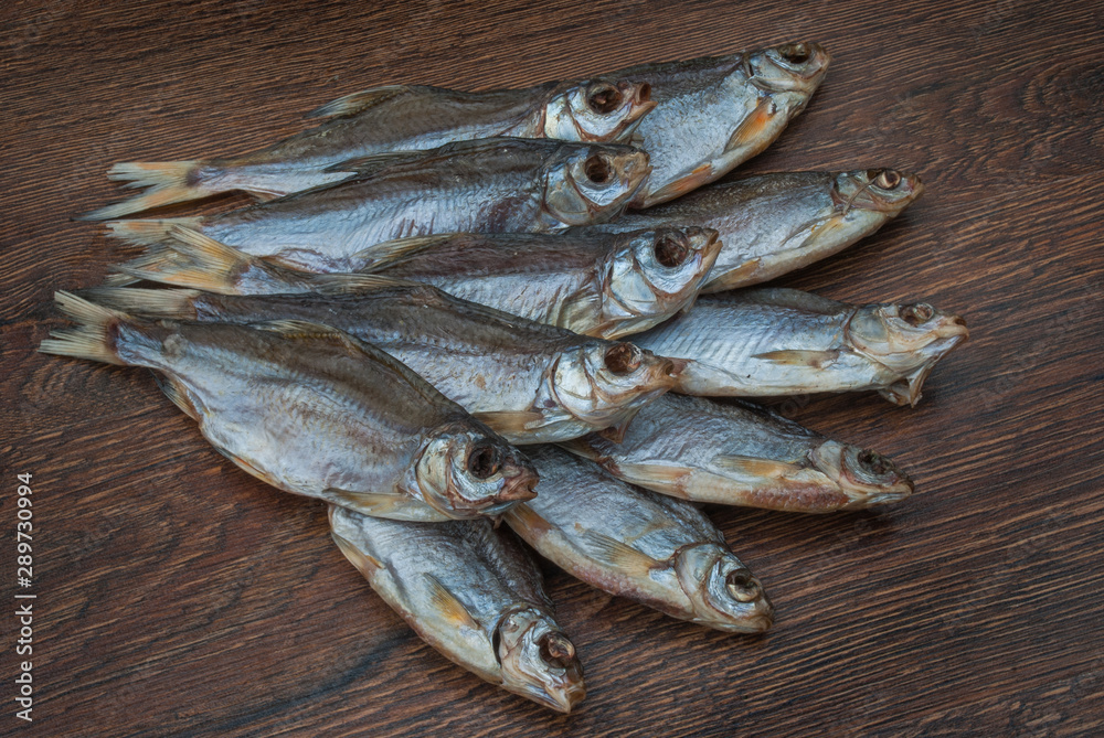 some dried fish on a dark wooden background some dried fish on a dark wooden background