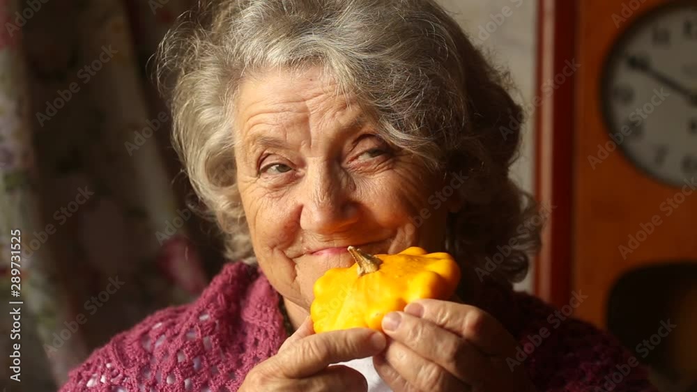 Elderly smile woman with a small beautiful yellow squash Elderly smile woman with a small beautiful yellow squash