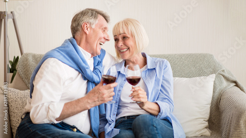 Loving senior couple drinking wine at home
