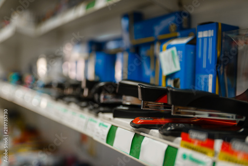 Shelf with staplers in stationery store, nobody