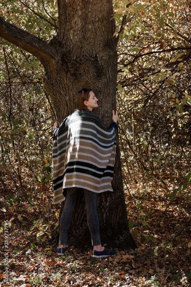 Young woman hugging a tree. Unity with nature, autumn forest Young woman hugging a tree. Unity with nature, autumn forest