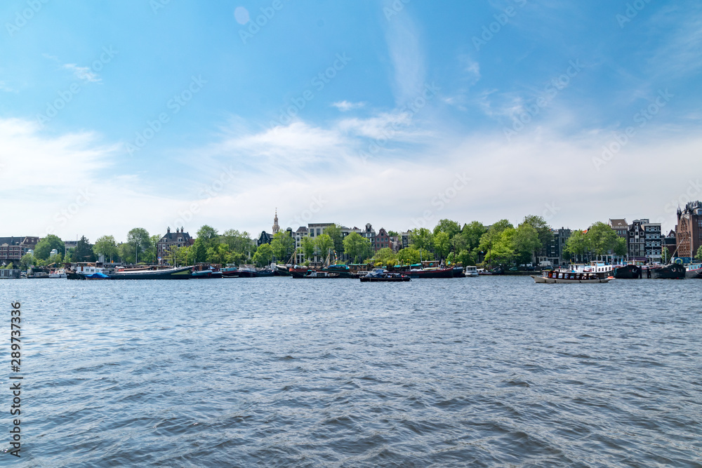 Oosterdok waterway with boats in Amsterdam, Netherlands. Oosterdok waterway with boats in Amsterdam, Netherlands.