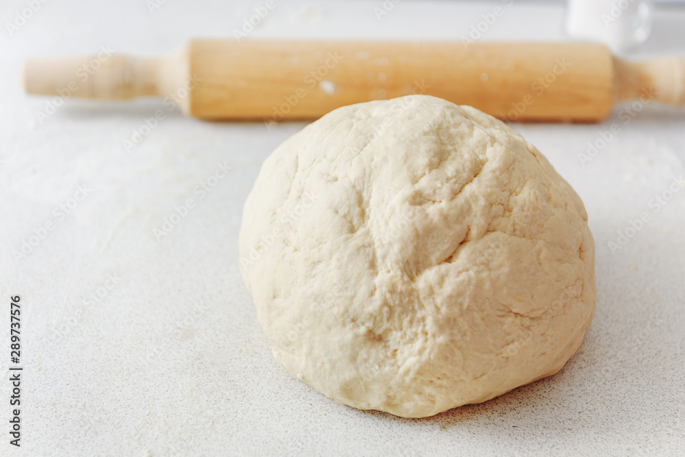 Dough with rolling pin. Flour on the table. Pizza dough. Rolling pin for the test. Dough with rolling pin. Flour on the table. Pizza dough. Rolling pin for the test.