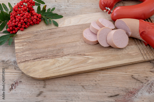 Swedish sausage- falukorv on a beautiful wooden table and autumn theme with rowan berries.