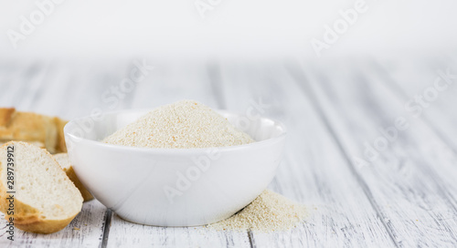Some fresh Bread Crumbs on wooden background (selective focus; close-up shot) photo