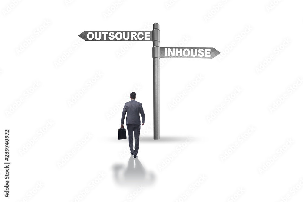 Businessman at crossroads deciding between outsourcing and inhou Businessman at crossroads deciding between outsourcing and inhou