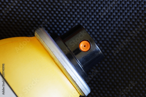 Sprayer of a yellow aerosol repellent bottle. Protection against insect bites. Close-up. Dark background photo