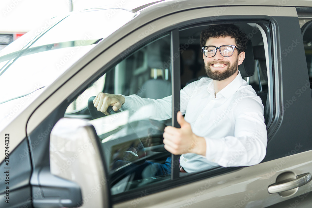Thumbs up. Portrait of a happy businessman showing thumbs up sitting in his new car Thumbs up. Portrait of a happy businessman showing thumbs up sitting in his new car