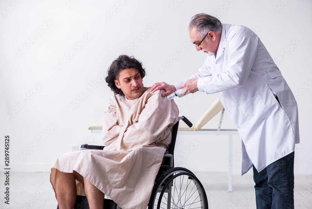 Old male doctor psychiatrist and patient in wheel-chair Old male doctor psychiatrist and patient in wheel-chair