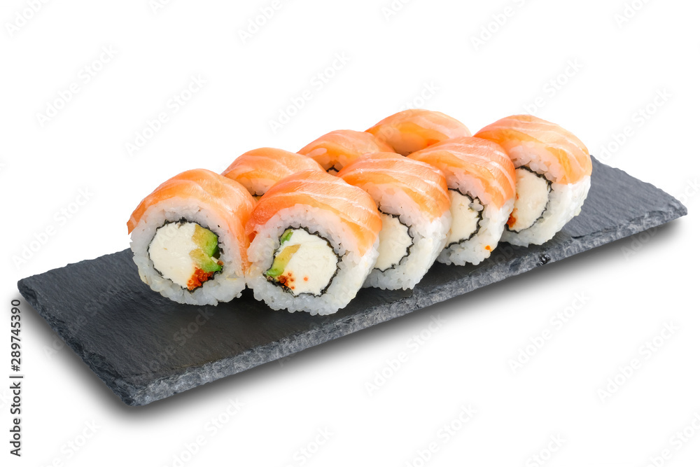 Sushi Rolls with salmon, avocado, flying fish caviar and Cream Cheese inside on black slate isolated on white Sushi Rolls with salmon, avocado, flying fish caviar and Cream Cheese inside on black slate isolated on white