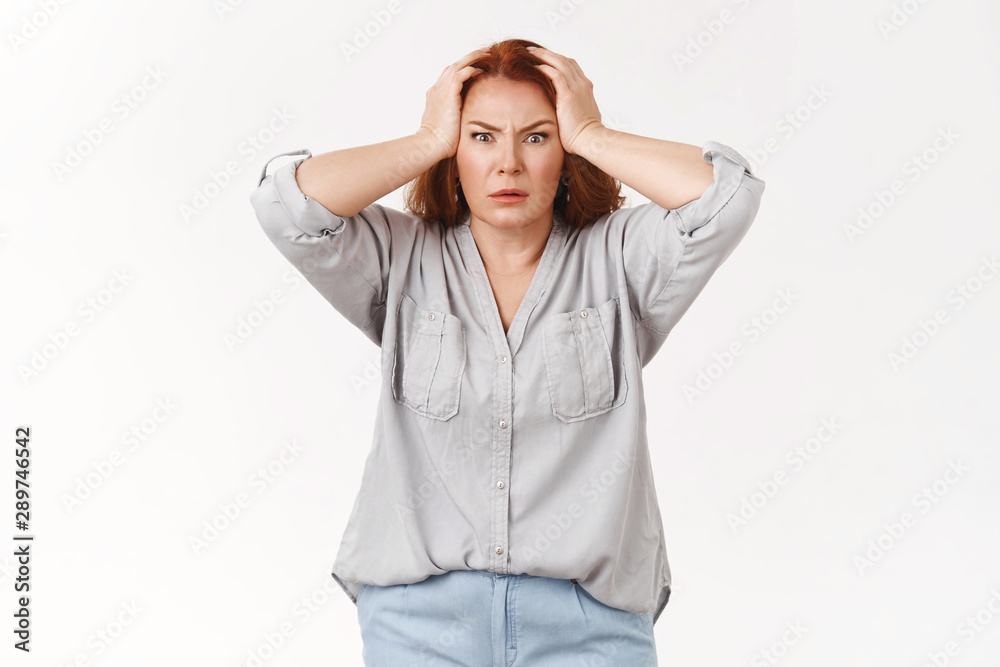What disaster. Shocked panic redhead woman grab head troubled frowning bothered feel pressured distress facing trouble terrible scene displeased huge mess kids made, standing white background What disaster. Shocked panic redhead woman grab head troubled frowning bothered feel pressured distress facing trouble terrible scene displeased huge mess kids made, standing white background