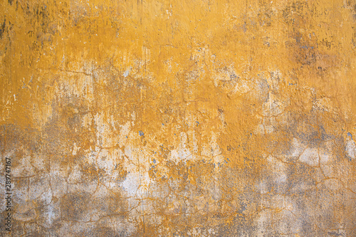 Grunge wall texture background. Paint cracking off dark wall with rust underneath. © panifuzja