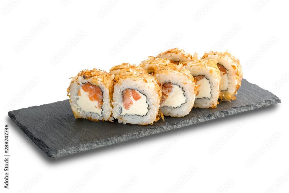 Sushi Rolls with salmon, tuna flakes and Cream Cheese inside on black slate isolated on white