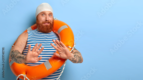 Fotografi Nervous bearded ginger guy makes refusal gesture, palms outstretched afraids of