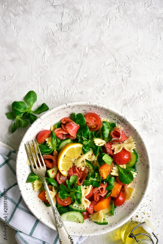 Pasta salad with vegetables and salted salmon. Top view with copy space.
