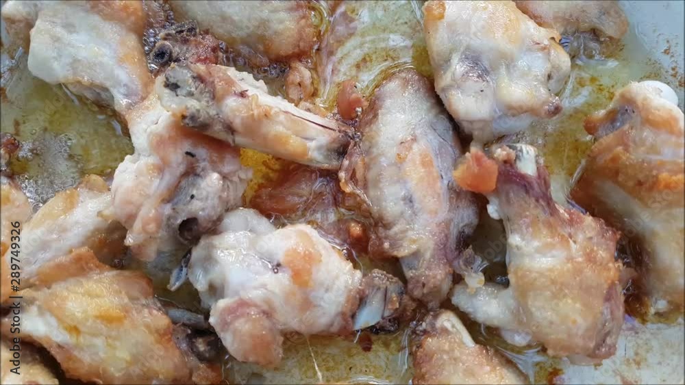 Chicken wings cooking on a pan.