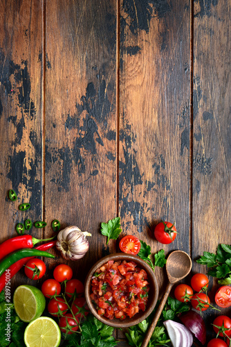 Tomato salsa (salsa roja) - traditional mexican sauce with ingredients for making. Top view with copy space.