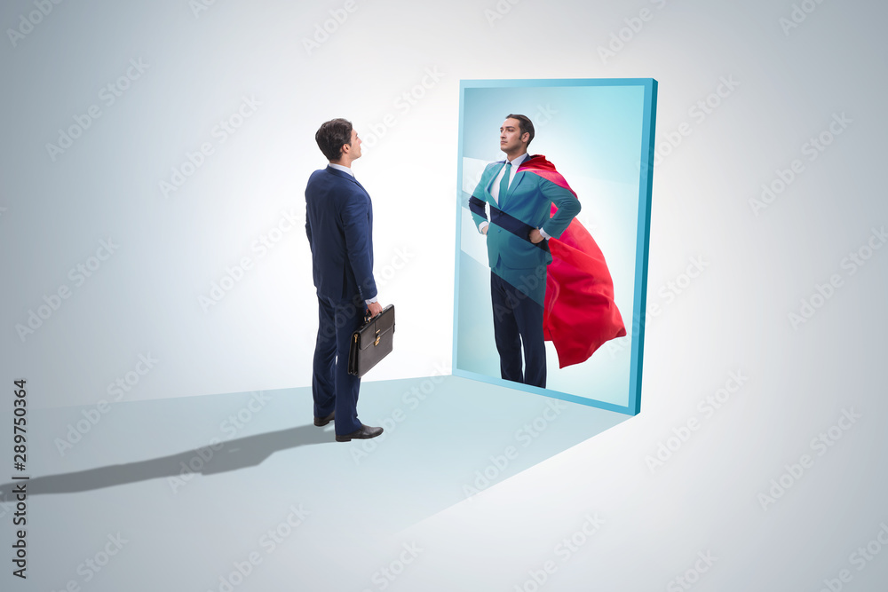 Businessman seeing himself in mirror as superhero