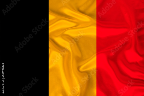 photo of the national flag of Belgium on a luxurious texture of satin, silk with waves, folds and highlights, close-up, copy space, travel concept, economy and state policy, illustration