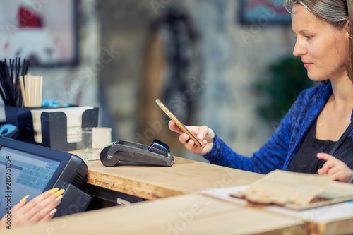 woman paying in cafe using phone application