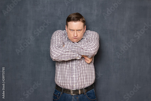 Portrait of angry displeased man holding arms crossed on chest