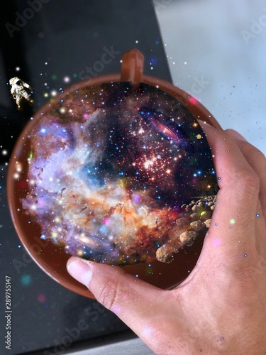 Illistrated picture of an astronaut floating over a coffee cup full of universe photo