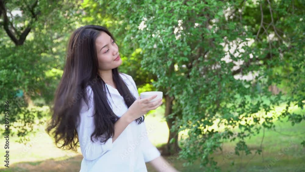4K Medium shot young pretty asian woman standing on cozy balcony in the morning drinking coffee from coffee cup for breakfast. Cute teenage girl relaxing on home balcony to get fresh air and sunlight 4K Medium shot young pretty asian woman standing on cozy balcony in the morning drinking coffee from coffee cup for breakfast. Cute teenage girl relaxing on home balcony to get fresh air and sunlight