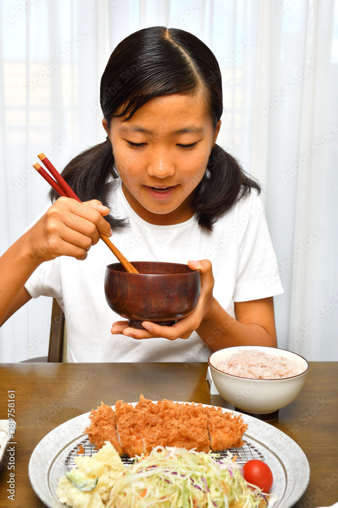 トンカツを食べる女の子