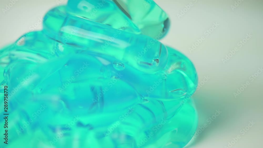 Amazing closeup macro shot of green blue gel with bubbles falling on a white plan table. Amazing closeup macro shot of green blue gel with bubbles falling on a white plan table.