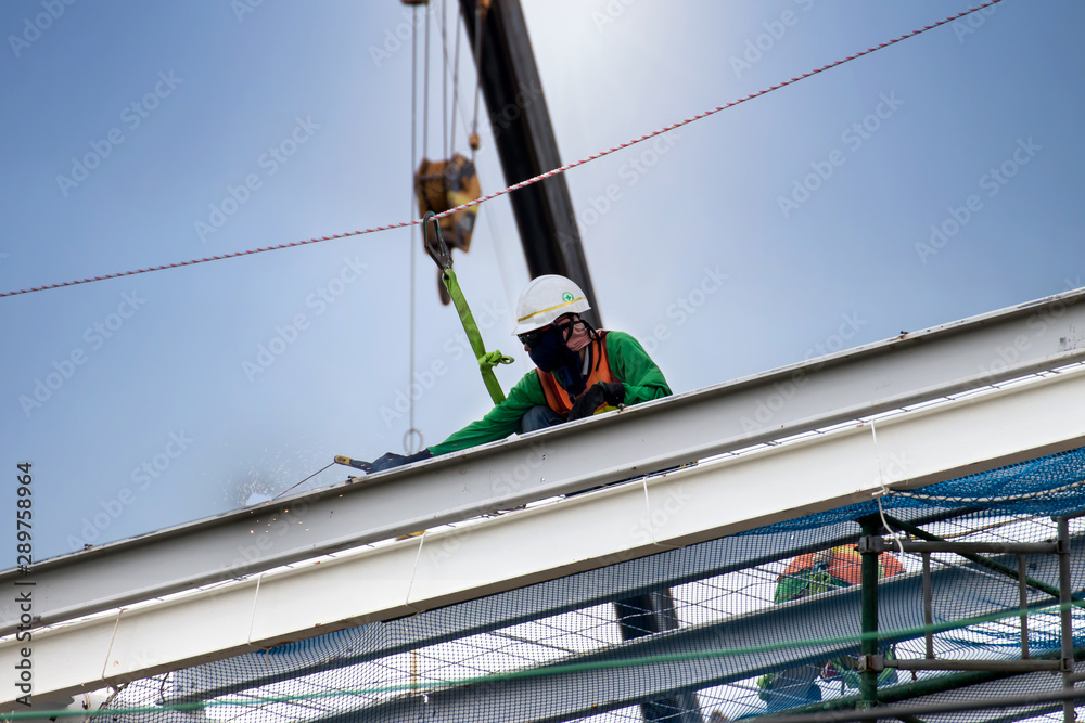 Man working on construction site with scaffold and building with sun background,scaffolding for construction factory