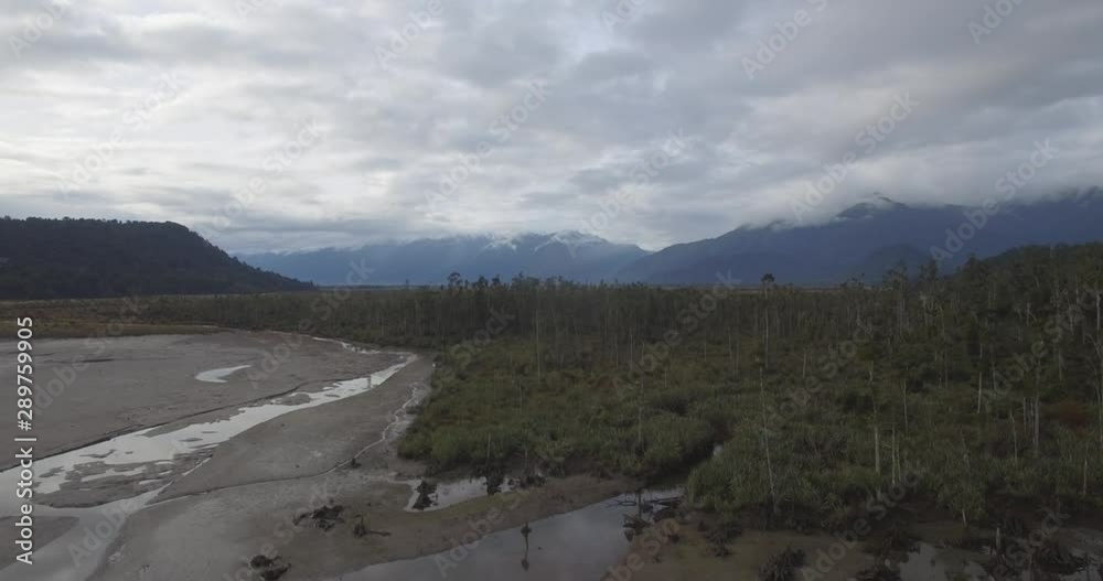 Ascending Aerial of Untouched Nature and Landscape of West Coast of New Zealand. Sandy Coast and Forest Under Southern Alps Ascending Aerial of Untouched Nature and Landscape of West Coast of New Zealand. Sandy Coast and Forest Under Southern Alps