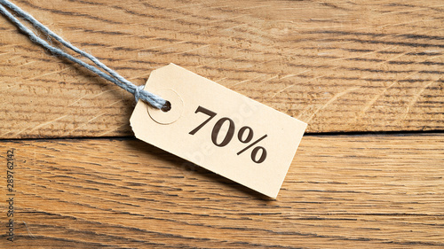 Hangtag with the message "70%" on wooden background