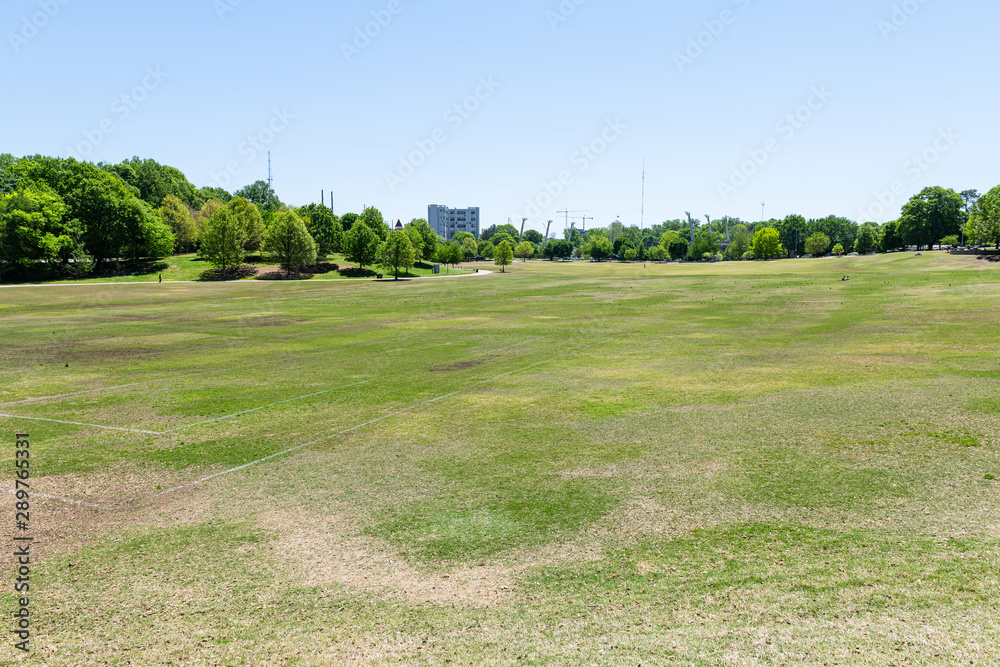 View in Piedmont Park in Georgia downtown with scenic green trees, grass lawn in summer at Atlanta, Georgia View in Piedmont Park in Georgia downtown with scenic green trees, grass lawn in summer at Atlanta, Georgia
