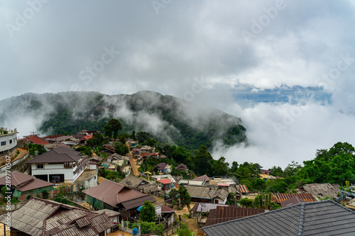 Misty mountain in the morning rainy season over small village at Doi Pha Hee countryside, Chiang Rai Thailand