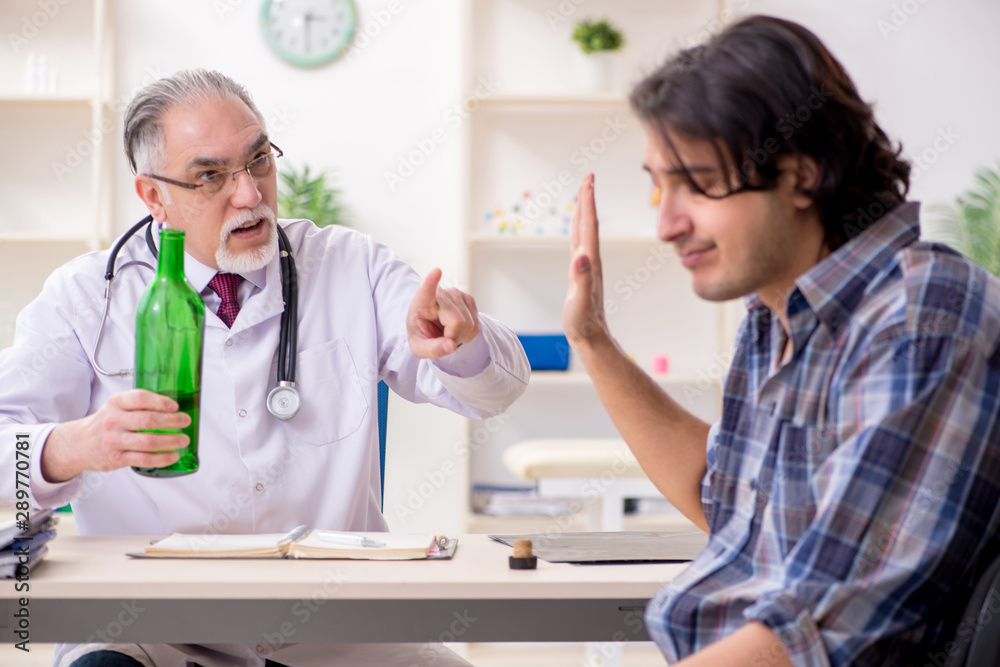 Young male alcoholic visiting old doctor Young male alcoholic visiting old doctor
