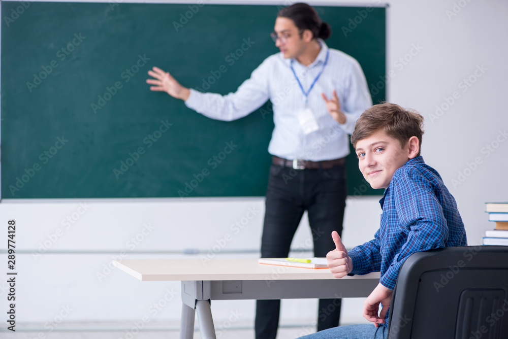 Young male teacher and boy in the classroom Young male teacher and boy in the classroom