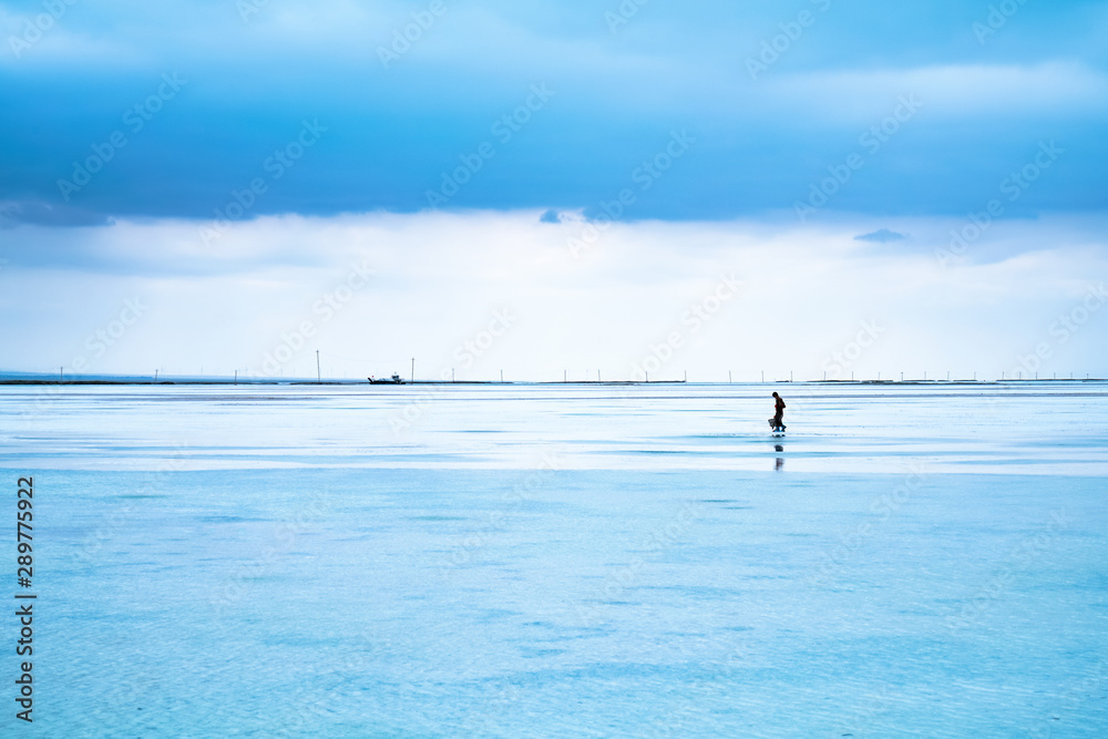 Fototapeta premium A person walking on the Chaka salt lake, Qinghai,China