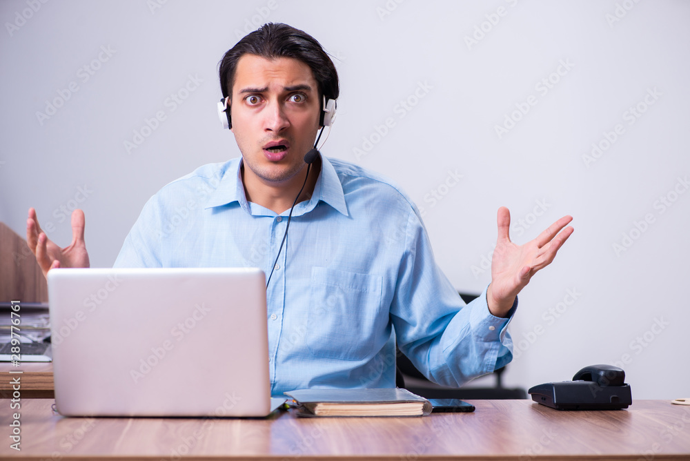 Call center operator working at his desk Call center operator working at his desk