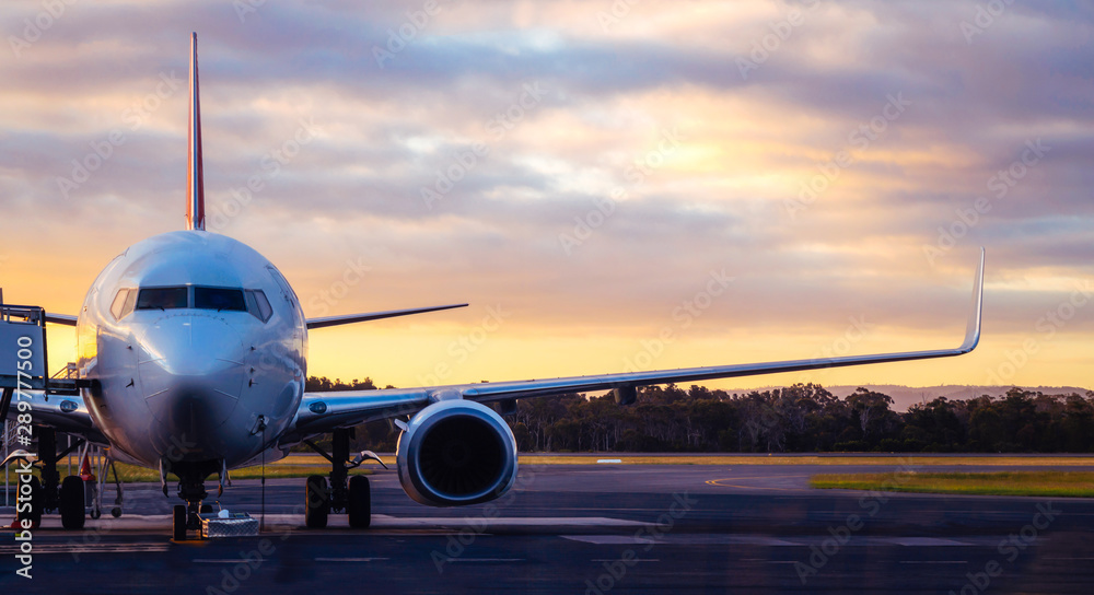Fototapeta Zmierzchu widok samolot na lotniskowym pasie startowym pod dramatycznym niebem w Hobart, Tasmania, Australia. Technologia lotnicza i koncepcja podróży po świecie.
